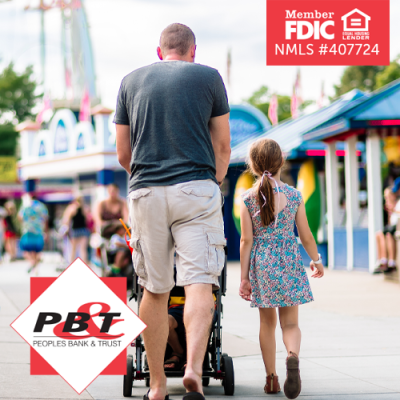 Dad pushing stroller with his daughter walking next to him at outdoor event
